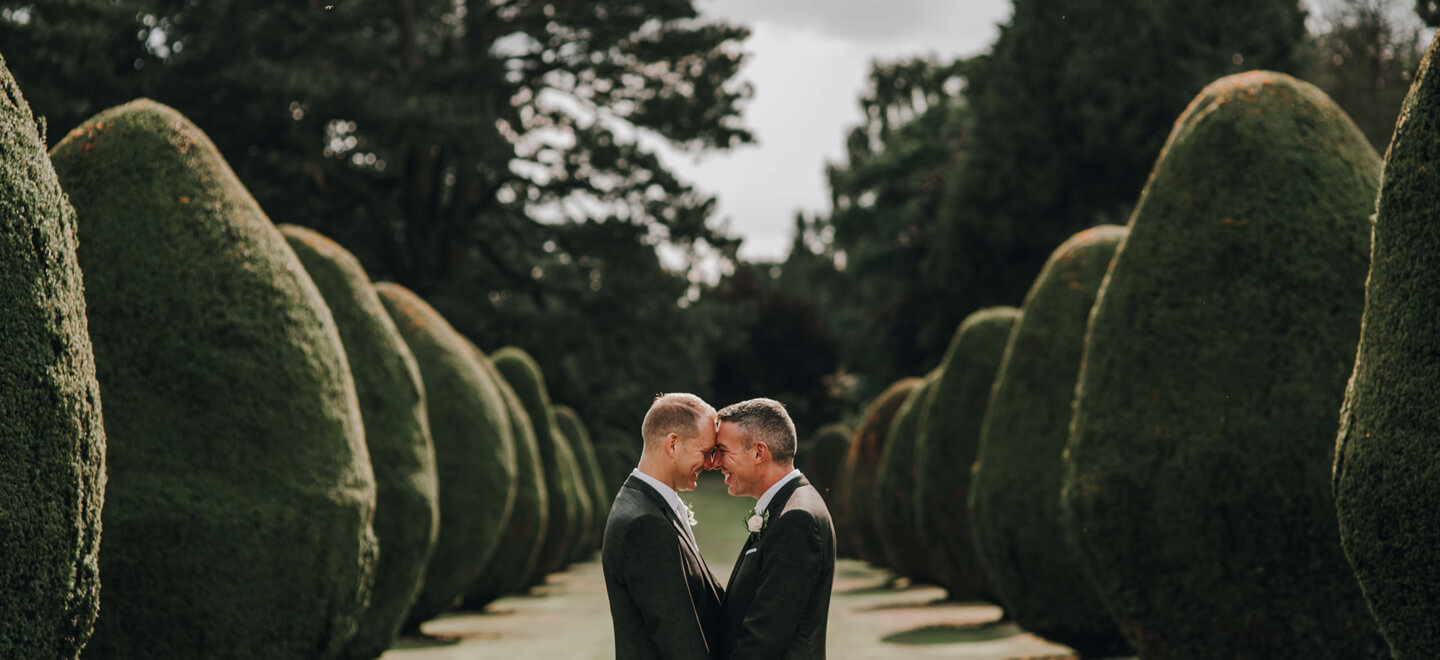 NEW gay couple by trees at the Elvetham hotel wedding venue Hampshire gay wedding guide image Rivendell Studio 1