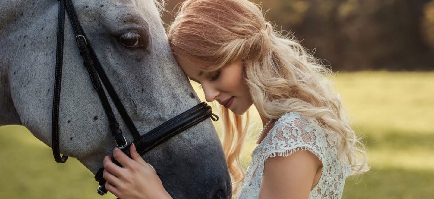Bride with horse at Woodstock Weddings and Events a barn wedding venue in York via the Gay Wedding Guide 1