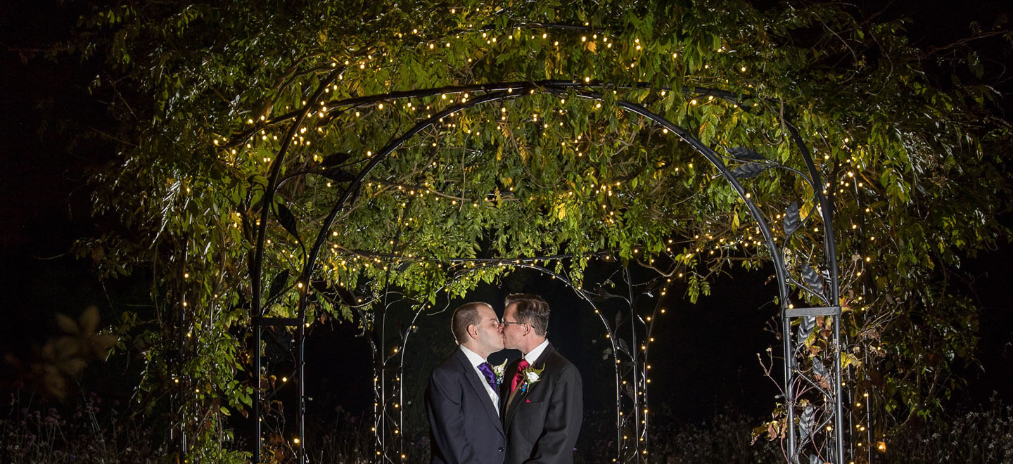 1440 Guy and Mark kiss under fairylights at their gay wedding Gaynes Park image copyright Steve Hobart Photography via the gay wedding guide 1