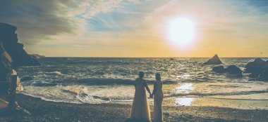 2 Lesbian Brides Hold Hands By Sea At Sunset Image By Gay Wedding Photographer Grw Photography2 6 380X174