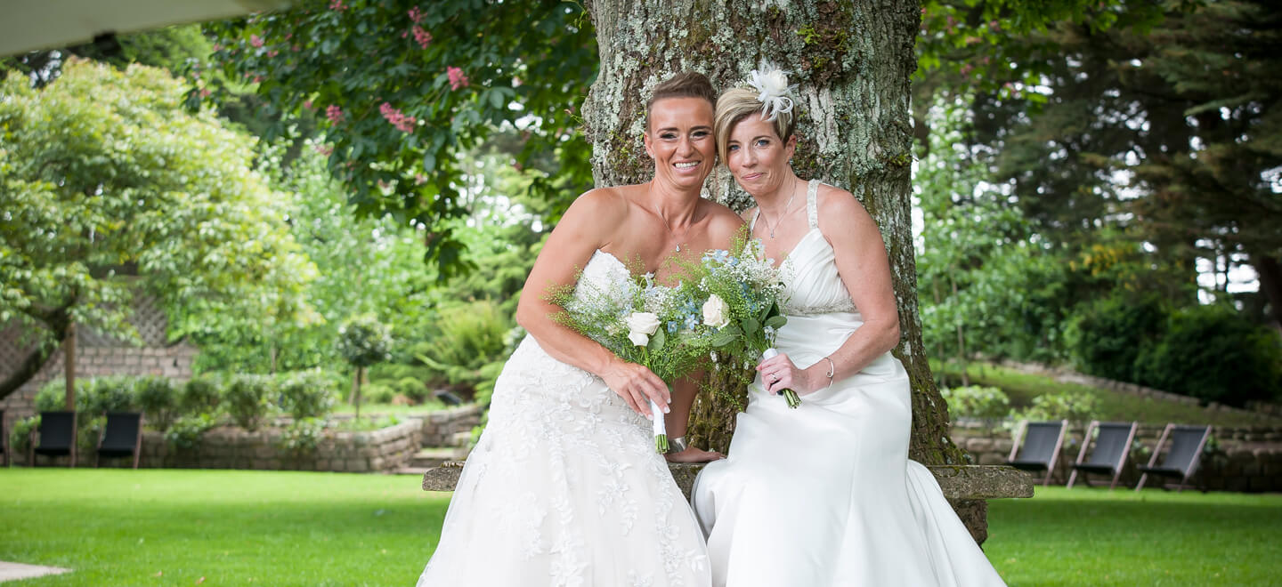5 Lesbian brides pose by tree at Wickwoods Country House and Spa West Sussex wedding venue gay wedding guide 9