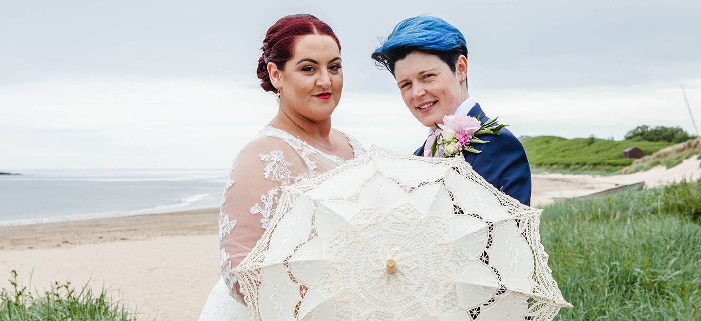9 lesbian brides stand by beach at lesbian wedding image by Newcastle wedding photographer Erica Tanith Photography via Gay Wedding Guide 6