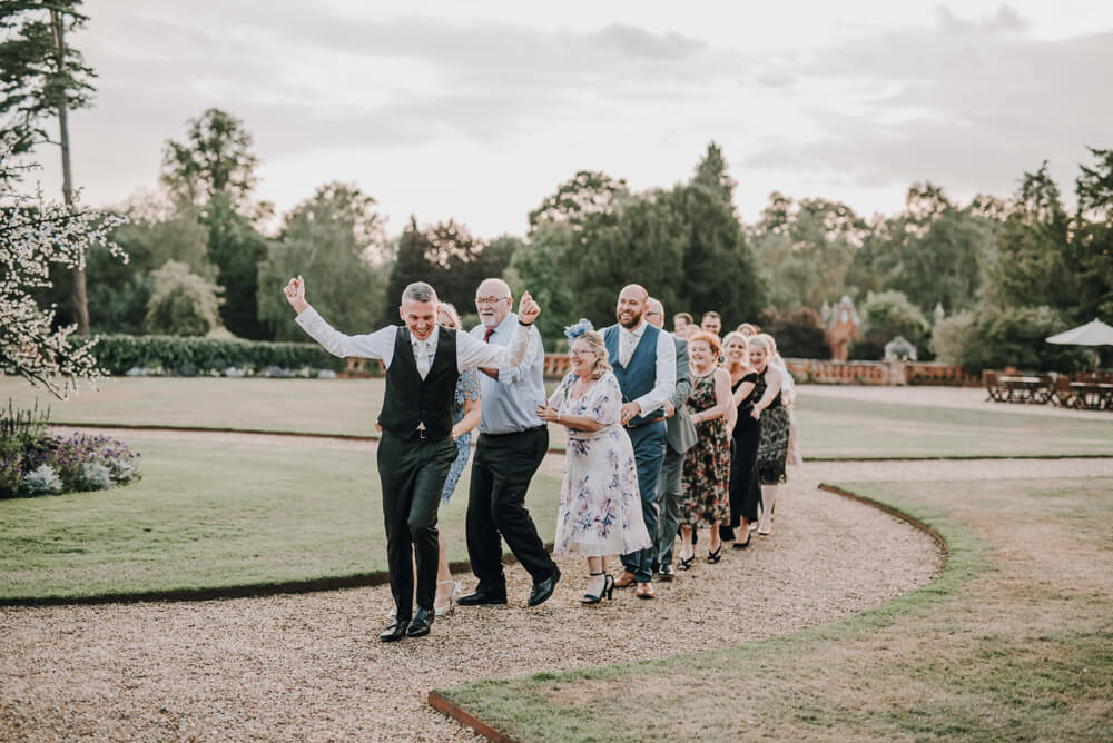 Aaron and Keith do conga 2 with guests at their gay wedding Hampshire at The Elvetham photographer DM Photography 1 5