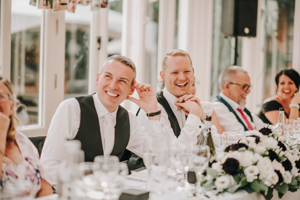 Aaron and Keith listen to speeches at their gay wedding Hampshire at The Elvetham photographer DM Photography 1 5