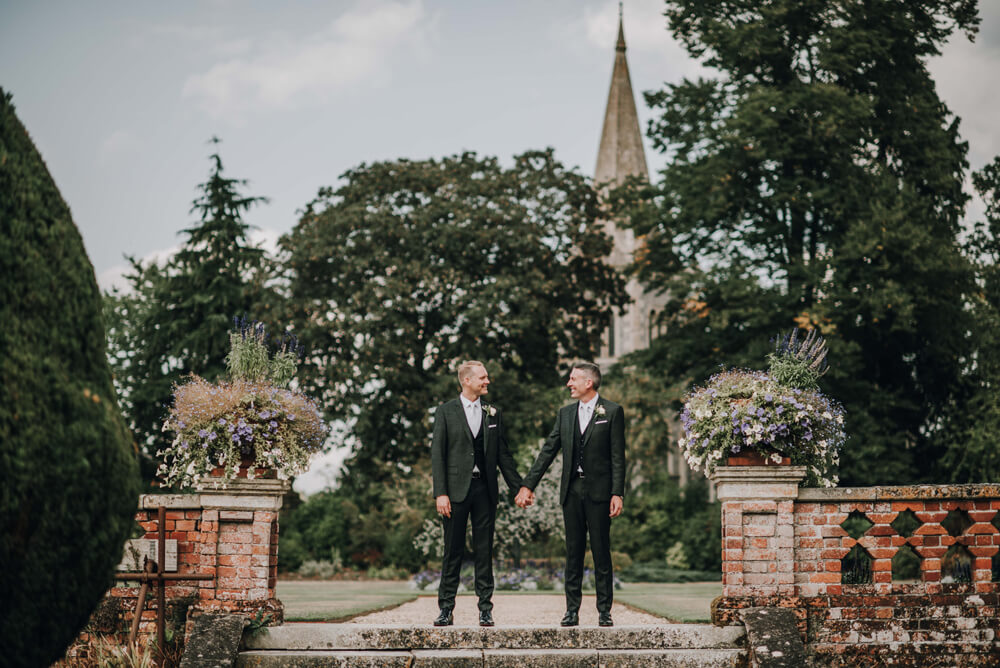 Aaron and Keith stand outside at black and white gay wedding Hampshire at The Elvetham photographer DM Photography 1 5
