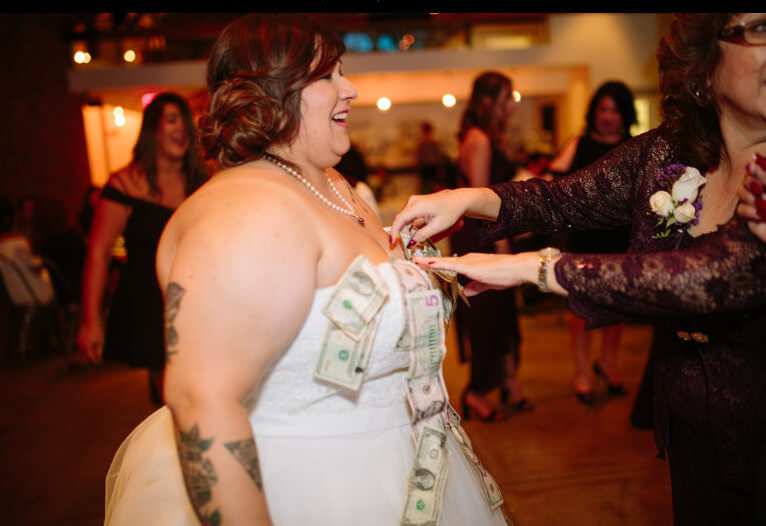 Amber and Alexis lesbian wedding pinning money on wedding dress images by Laarne via gay wedding guide 1 5