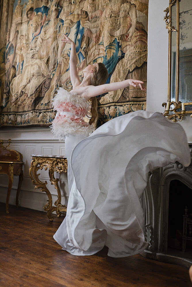 Ballerina dances wearing white feather in white dress at Swan Lake wedding shoot styled via Gay Wedding Guide 8
