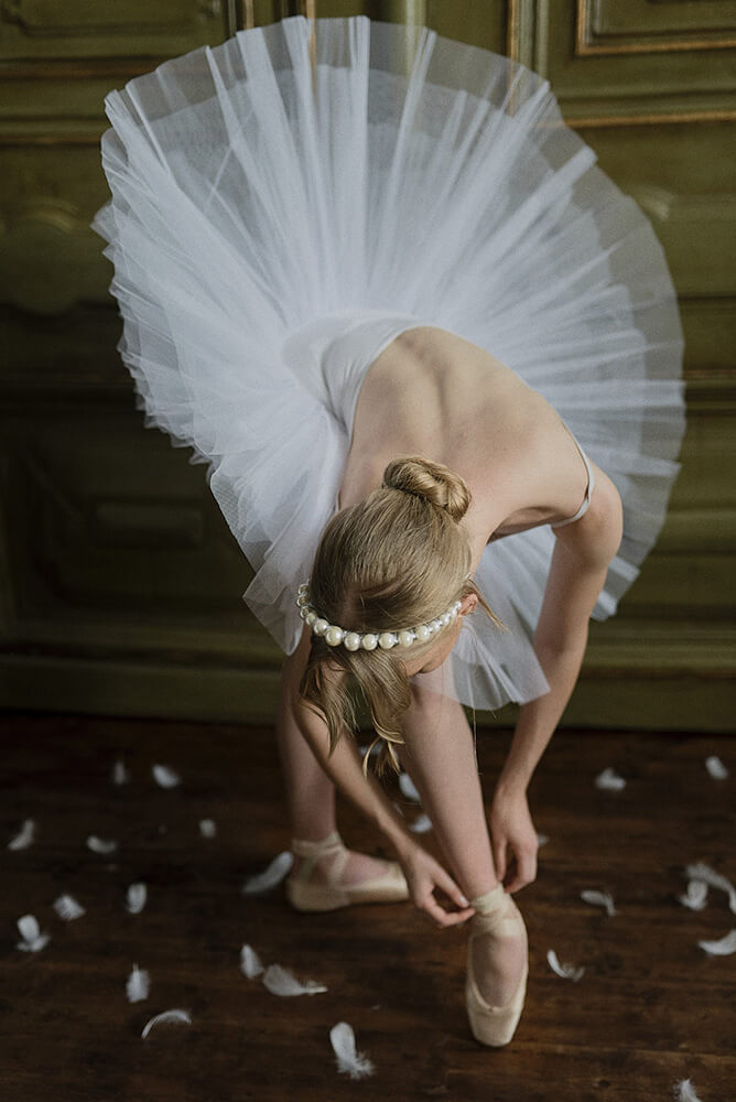 Ballerina ties ballet shoes in Swan Lake wedding shoot styled via Gay Wedding Guide 8