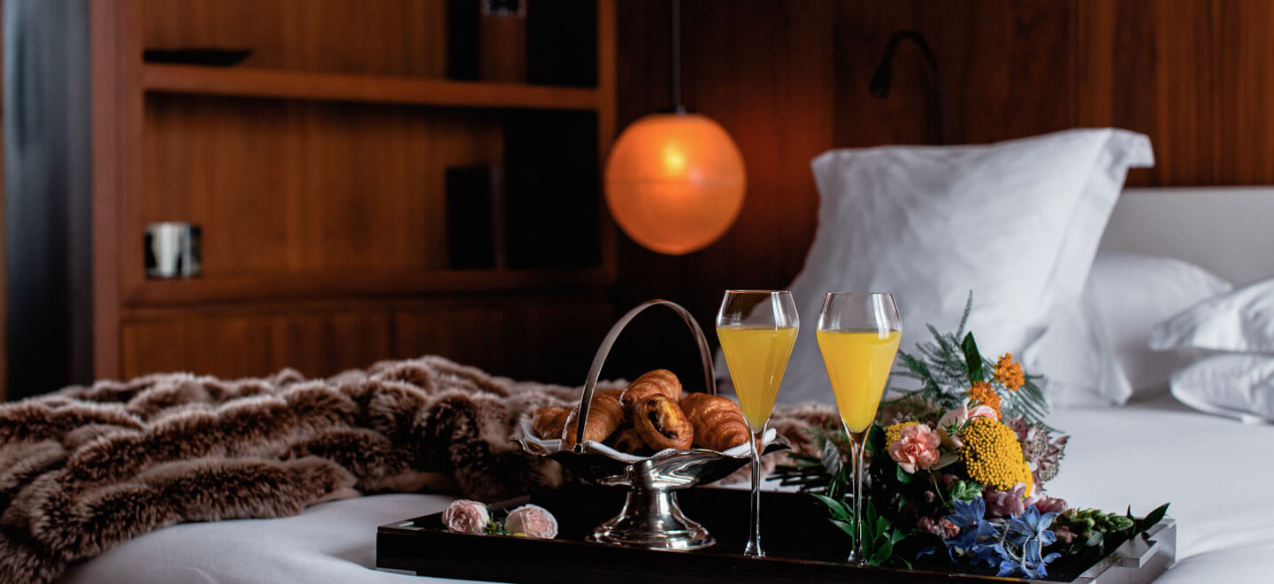 Breakfast tray on a bed at The London EDITION hotel soho wedding venue gay wedding guide 9