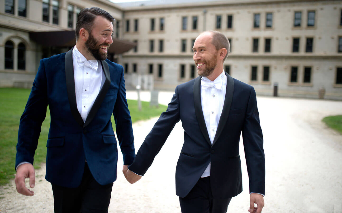 Chris and Ben walk hand in hand towards their gay wedding gatsby themed gay wedding guide 3 5