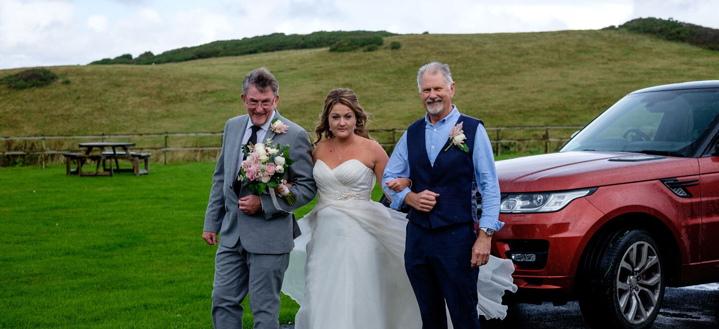 Dads with bride at Emily Jodie lesbian wedding Devon at Ocean Kave copyright Michael Wells via the Gay Wedding Guide 3 5