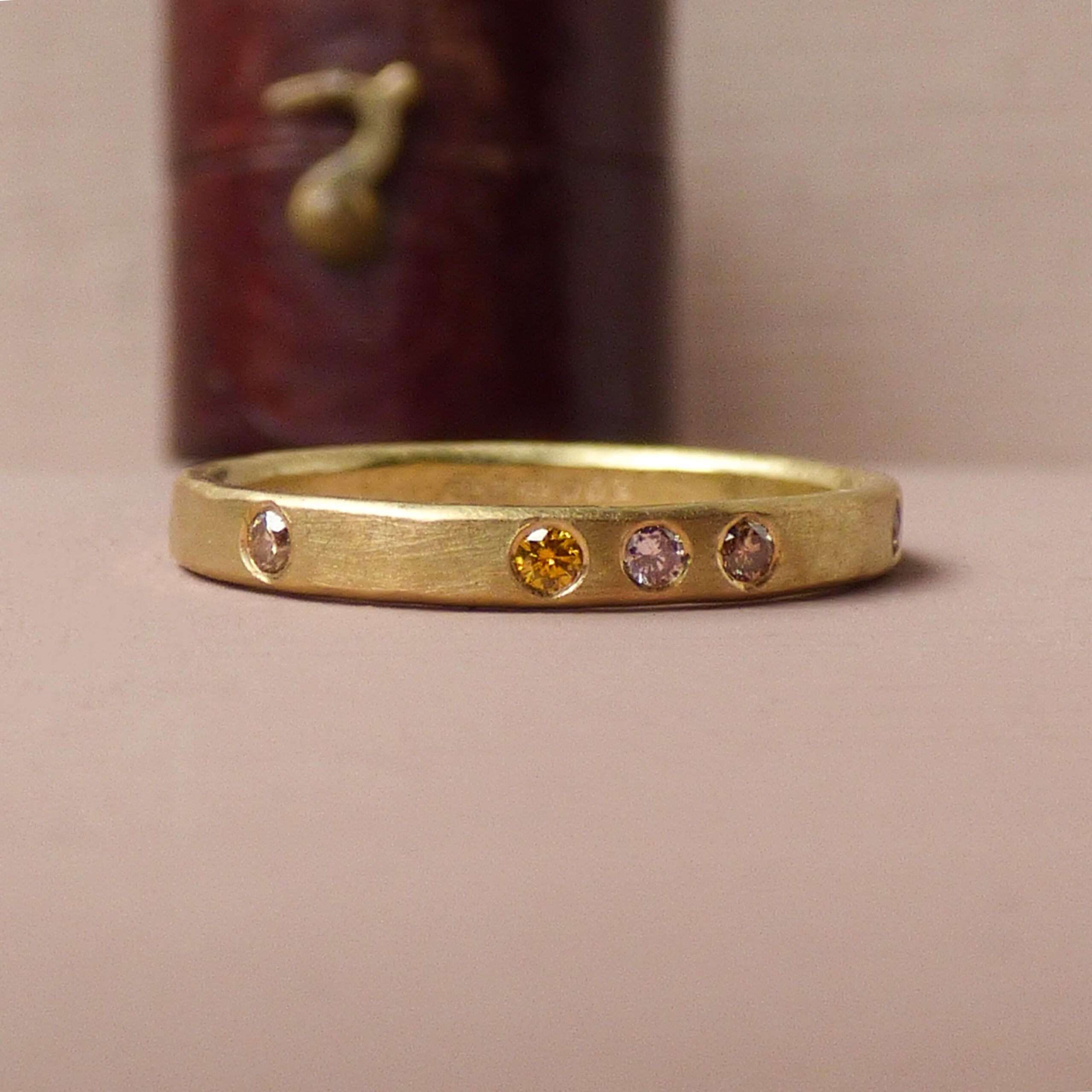 Dusk ethical wedding ring made with 18ct Fairtrade gold and pink chocolate and mandarin coloured diamonds