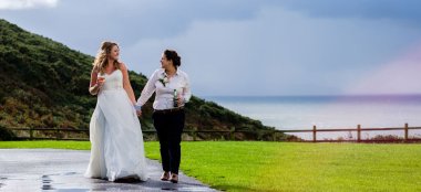Emily Jodie Outside With Drinks At Their Lesbian Wedding Devon At Ocean Kave Copyright Michael Wells Via The Gay Wedding Guide 3 5 380X174