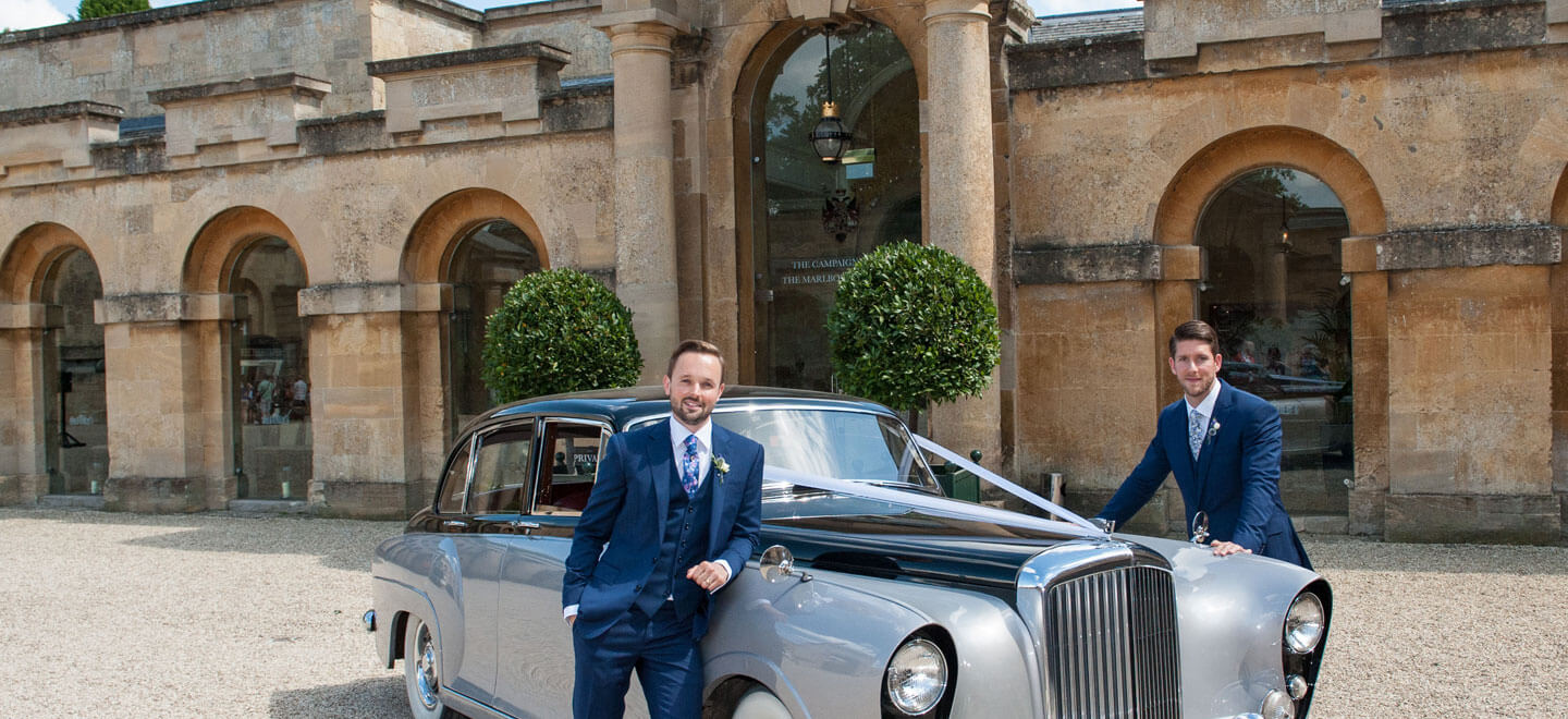 Gay couple with vintage car at Blenheim Palace wedding venue Oxfordshire gay wedding guide 9