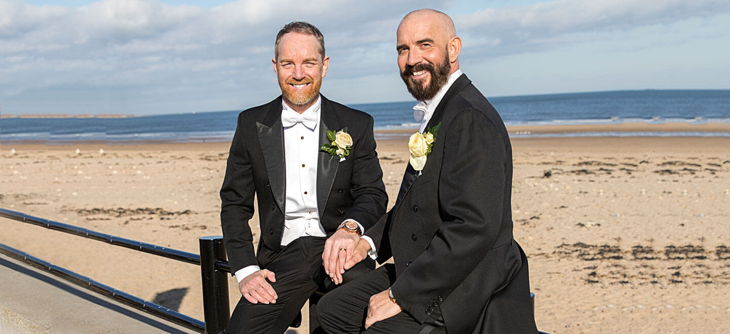 Glen Jason sit by beach at their gay wedding photographer This World Wedding Photography via Gay Wedding Guide 6