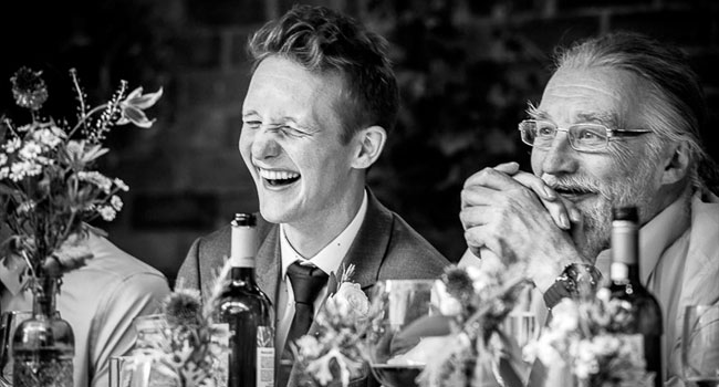 Groom laughs next to guest image shot a manchester gay wedding by James Tracey Photography a gay wedding photographer in Manchester via the Gay Wedding Guide 3 5