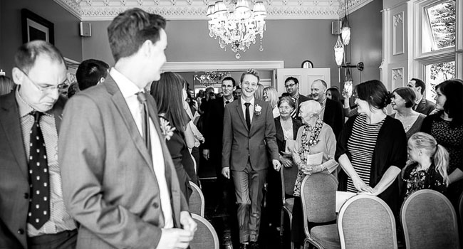 Groom walks up the aisle at gay wedding image by James Tracey Photography a gay wedding photographer in Manchester via the Gay Wedding Guide 3 5