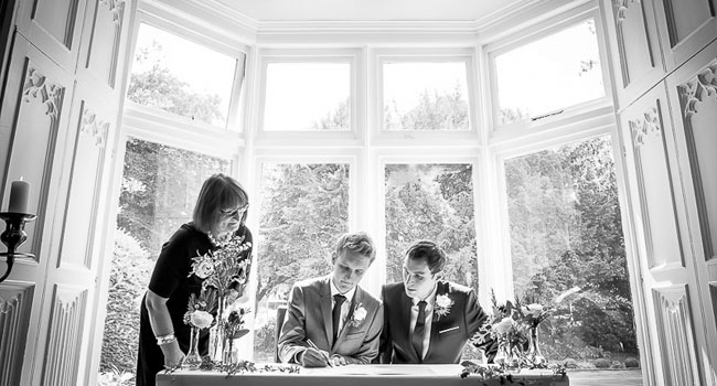 Grooms sign the register at their gay wedding in manchester image by James Tracey Photography a gay wedding photographer in Manchester via the Gay Wedding Guide 3 5