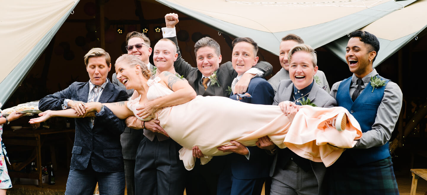Guests carry Jessica at jamie and Jessica lesbian wedding photograph by LEA Attentive via Gay Wedding Guide 6
