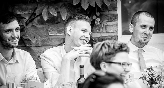 Guests smile during speeches image shot a manchester gay wedding by James Tracey Photography a gay wedding photographer in Manchester via the Gay Wedding Guide 3 5