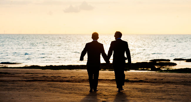 Guy and Andrew walking on the beach at sundown gay wedding margate bay photo by Webb Weddings 3 5