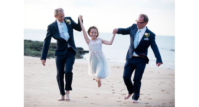Guy and Andrew walking on the beach with their flowergirl gay wedding margate beach photo by Webb Weddings 3 5