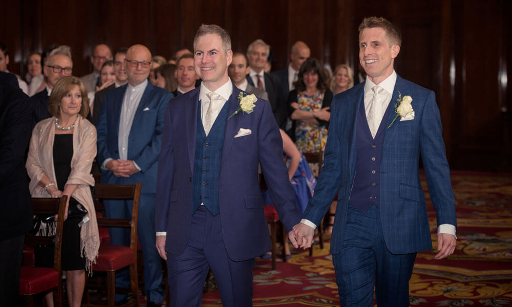 Hand in hand grooms at the real gay weddings of Gareth and Paul at Merchant Taylors Hall London image by Emir Hasham via the Gay Wedding Guide 1 5