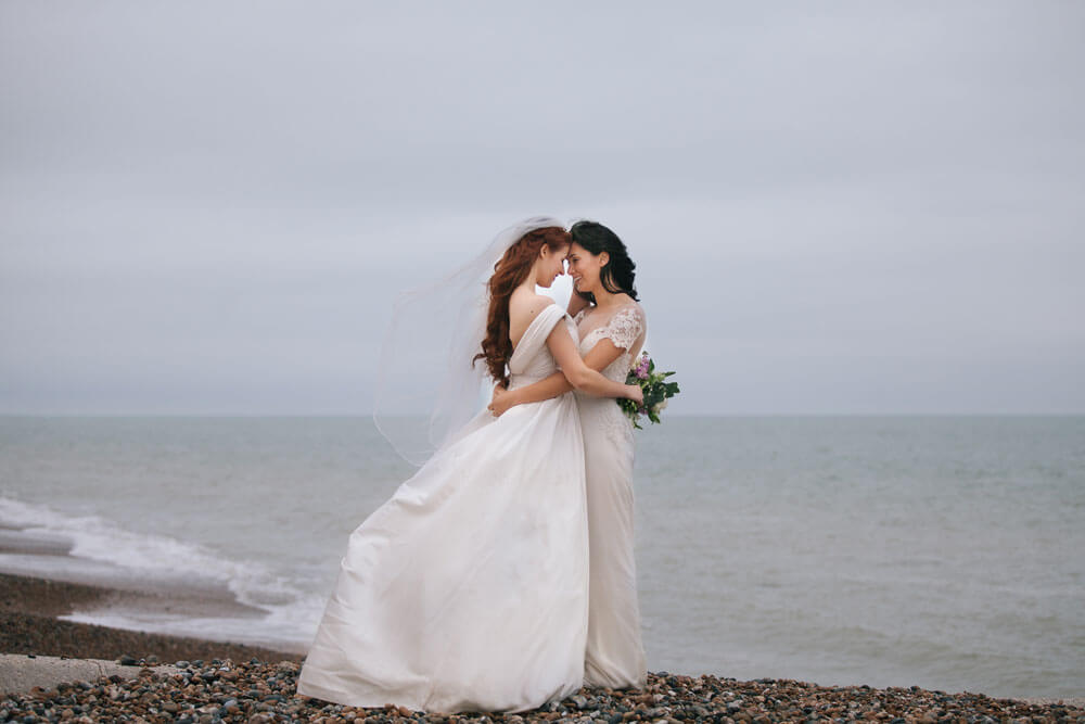 Jessie and Claudia hug at their 2 Brighton Beach Lesbian Wedding Shoot image copyright Rachel Movitz Weddings via the Gay Wedding Guide 1 5