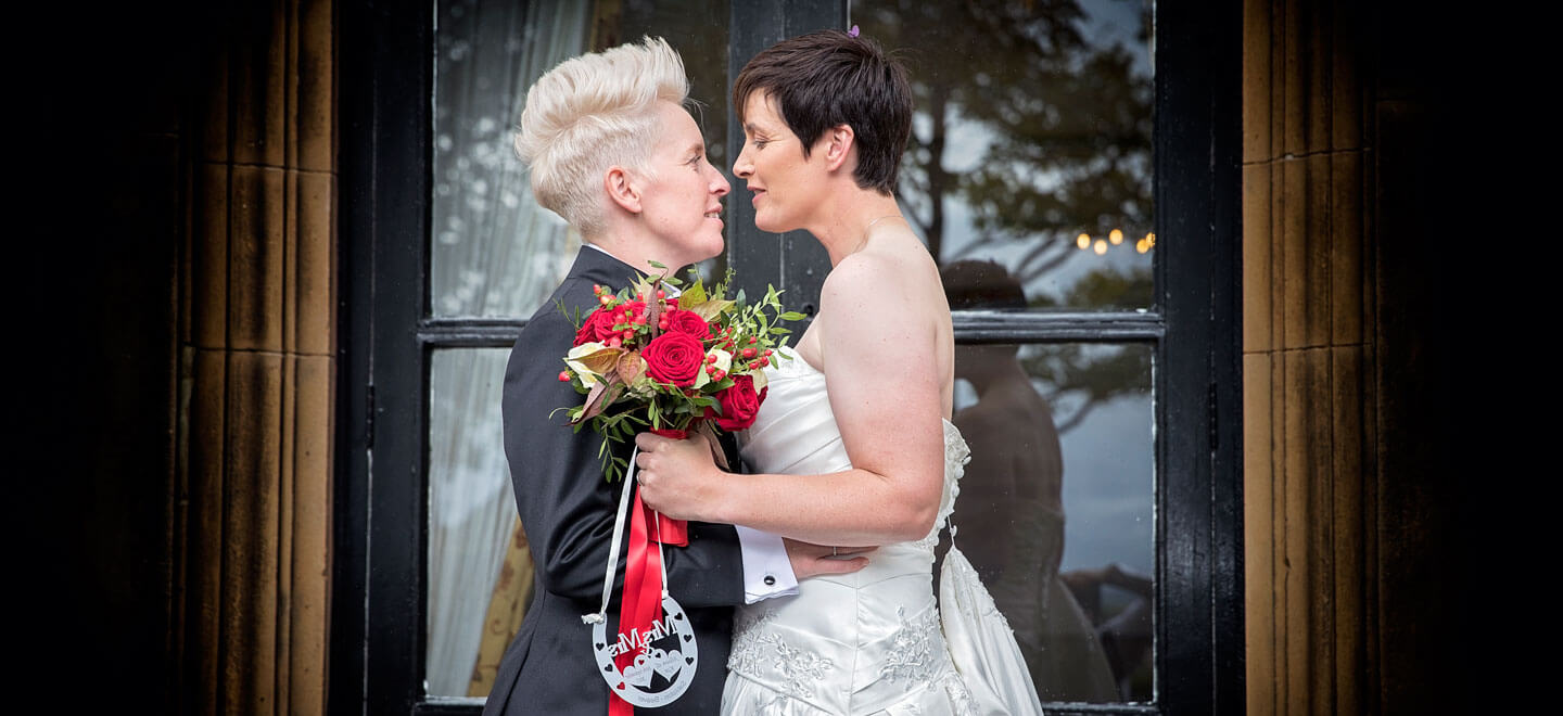 Kat and Ali infront of a door at their lesbian wedding photographer This World Wedding Photography via Gay Wedding Guide 6