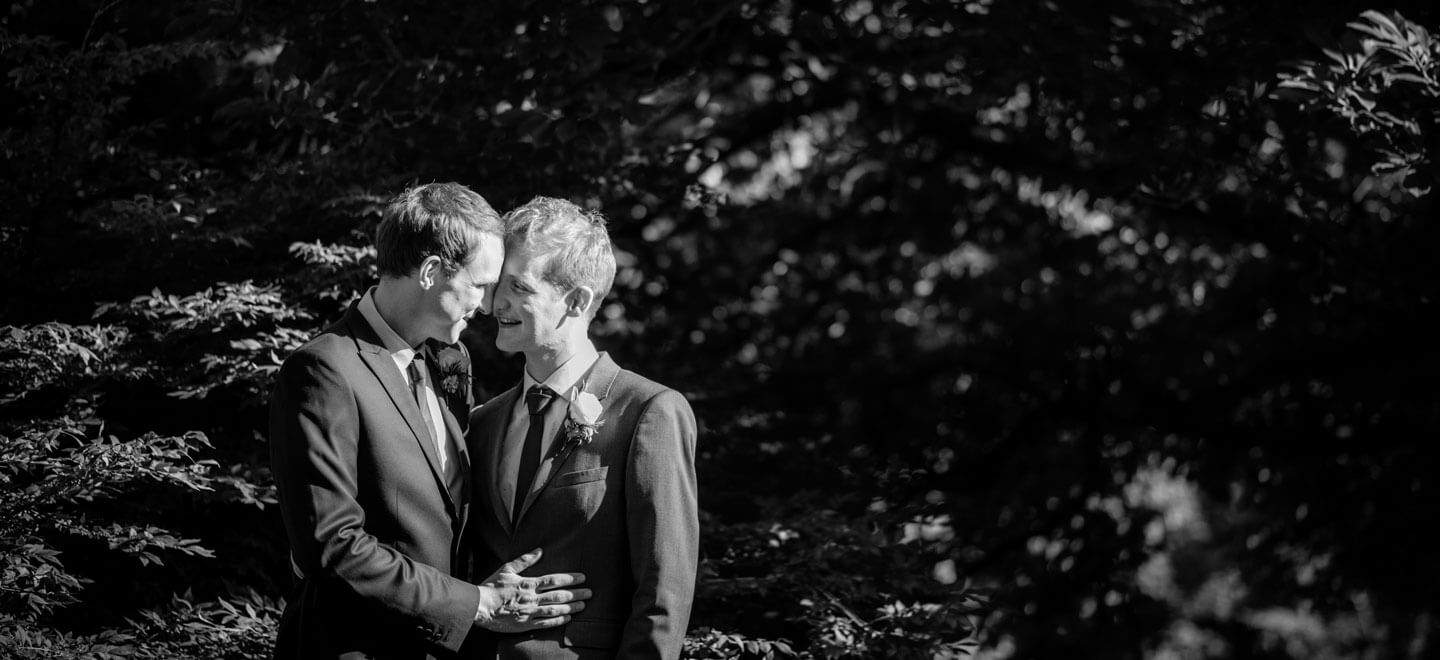Kenny and Richard cuddling in the garden by James Tracey gay wedding photography via the gay wedding guide 6