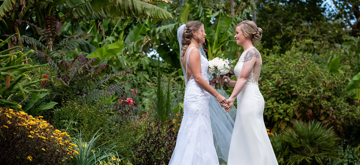 Lesbian brides in garden at Wakehurst a gay wedding venue West Sussex image via The Gay Wedding Guide 9