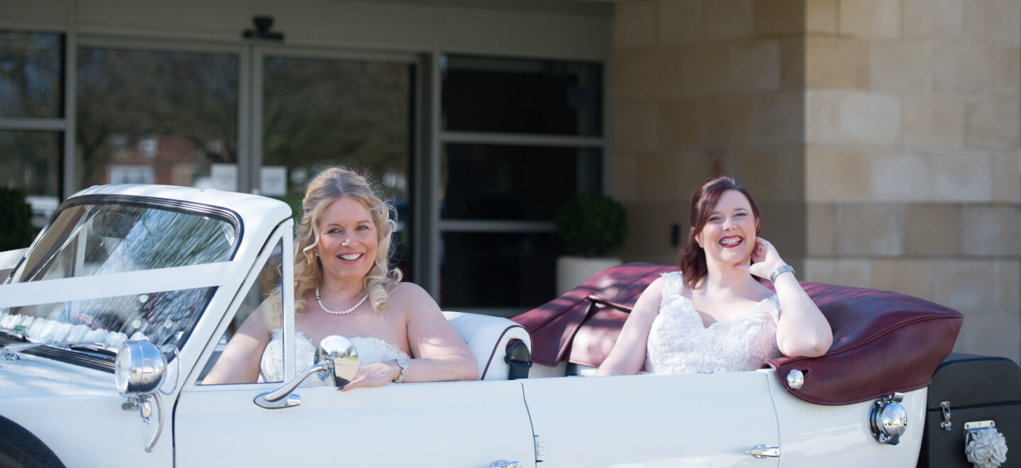 Lesbian brides in vintage car at wedding reception Alexandra House country house wedding wiltshire gay wedding guide 9