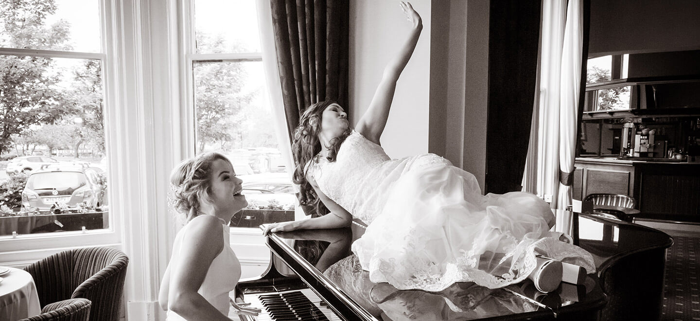 Lesbian brides on the piano photograph by Paul Walker Photographer Gay Wedding Guide 6