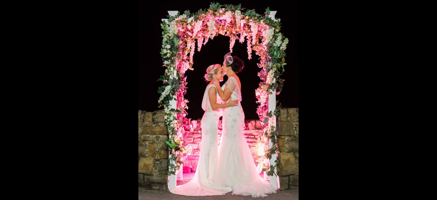 Lesbian wedding brides under floral archimage copyright Michael Love lesbian wedding photographer Ireland 6