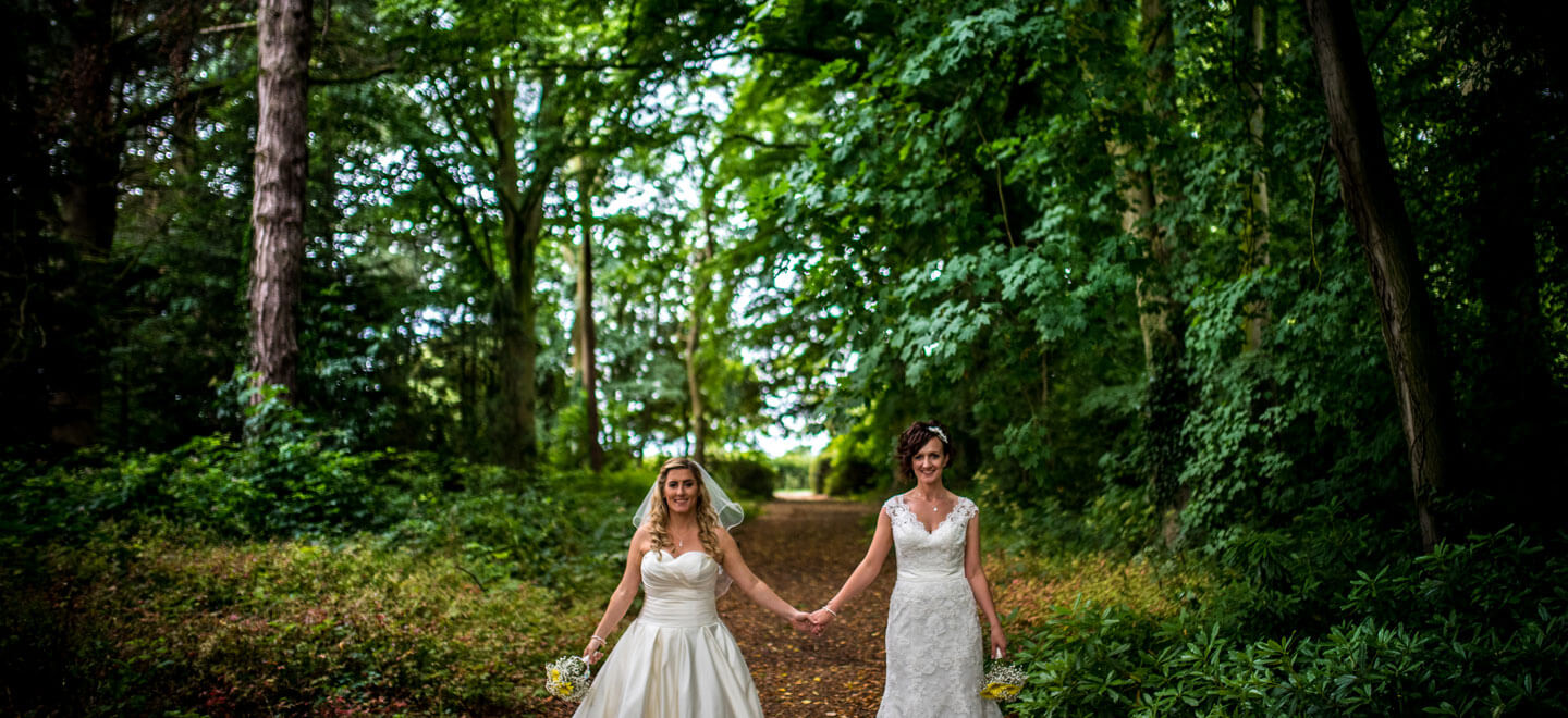 Lynsey and Joanne holding hands in the woods by James Tracey lesbian wedding photography via the gay wedding guide 6