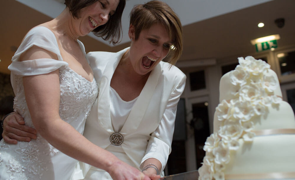 Mrs Mrs Hucker Shaw cut the cake at their lesbian wedding image copyright Ragdoll Photography via The Gay Wedding Guide 3 5