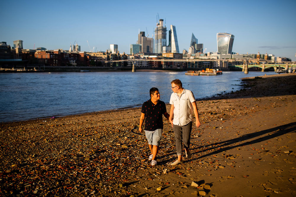 Neill Iggy hold hands walking along river bank during Gay Engagement shoot on London Southbank image by Engagement Chapter via Gay Wedding Guide 1 4