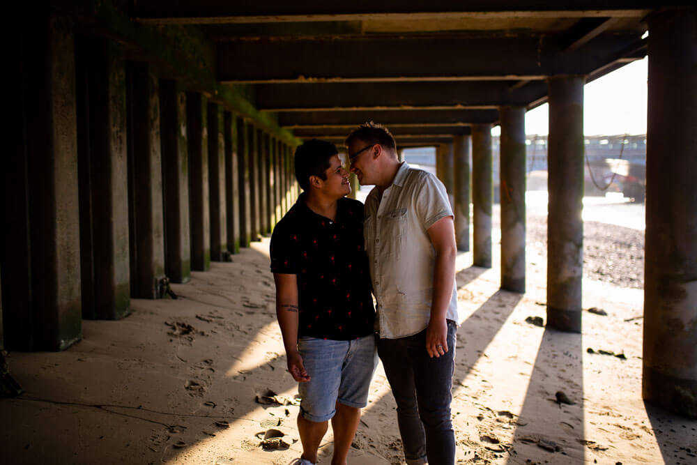 Neill Iggy look at each other under bridge on Gay Engagement shoot on London Southbank image by Engagement Chapter via Gay Wedding Guide 1 4