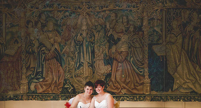 Rachel and Michelle infront of great tapestry image shot by Ragdoll Photography via The Gay Wedding Guide 3 5