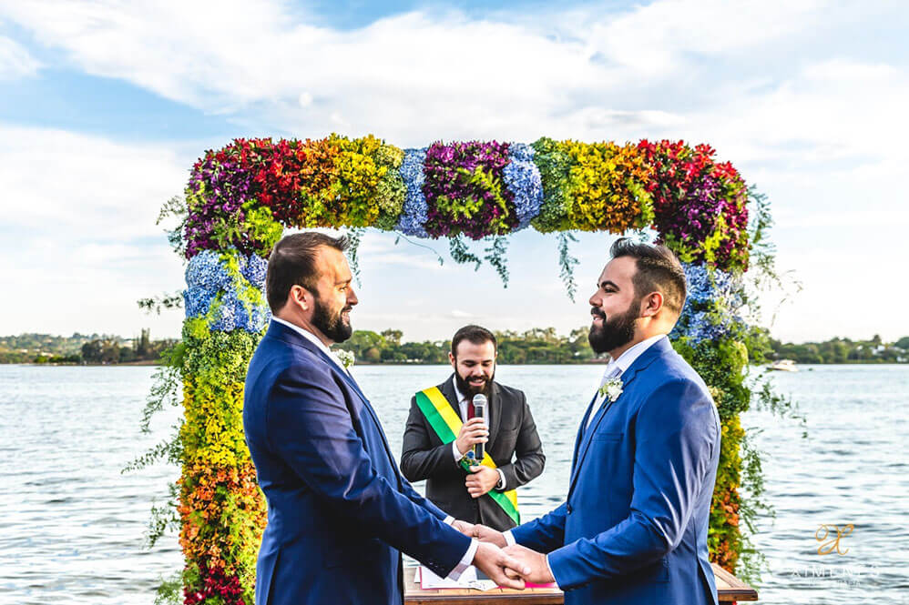 Saying vows under floral arch at Pedro and Pedro gay wedding Brasil 1 5