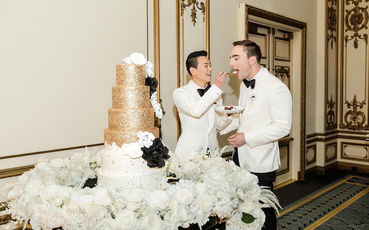 derrick and michael taste their cake at their gay wedding party 5