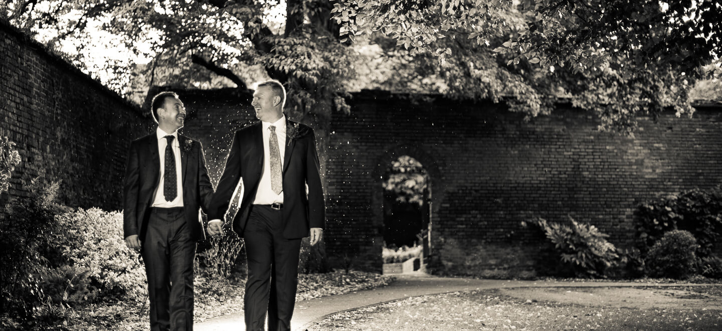 gay grooms walk hand in hand as rain falls image by Pike Photography via gay wedding guide 6
