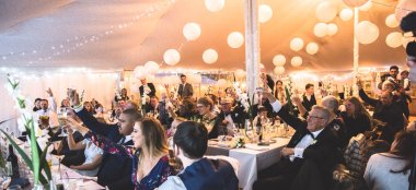 Guests Raise Their Glasses At A Wedding At The Perch Rustic Wedding Venue Oxford Gay Wedding Guide 9 380X174