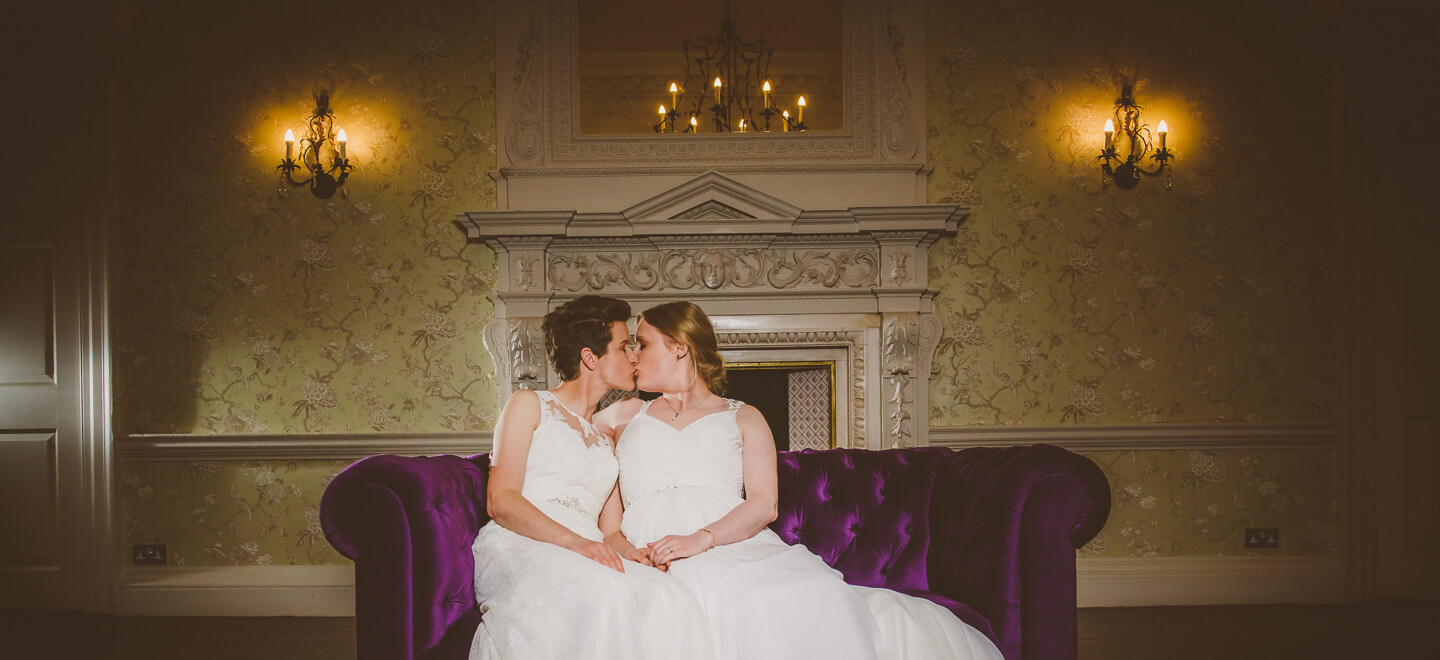 lesbian brides kiss on chaise long by gay wedding photography Pike Photography via gay wedding guide 1 6