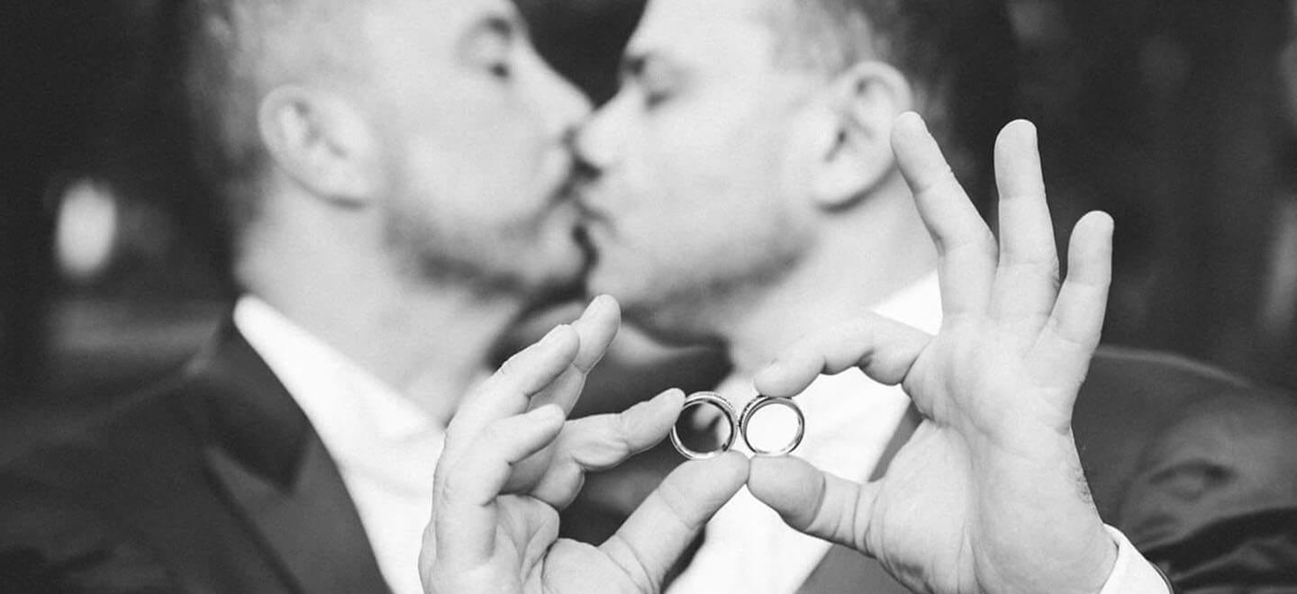 orchestra weddings gay couple kissing and holding their wedding rings 6