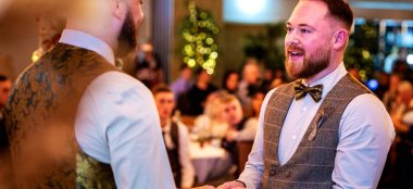 Two Gay Grooms Holding Hands And Declaring Love To Each Other At Oec In Sheffield Via Gay Wedding Guide 9 380X174