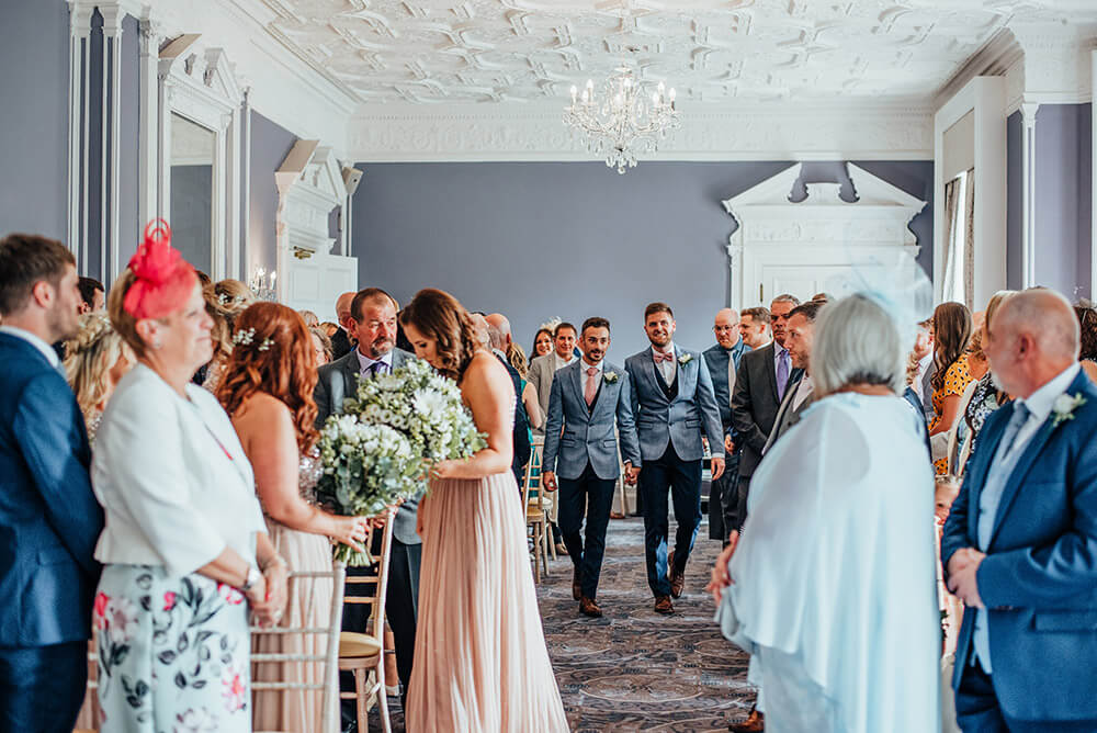 walking up the aisle at Lee and Simon Gay wedding at Bombay Sapphire Distillery Gay Wedding Guide image by This and That Photography 1 5