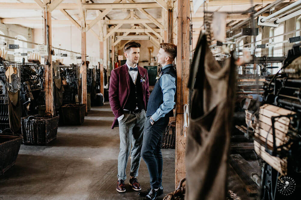 Gay couple lean against post in styeld gay engagement shoot at Germany fabric factory.1 Image by JuliaBartelt 1 5