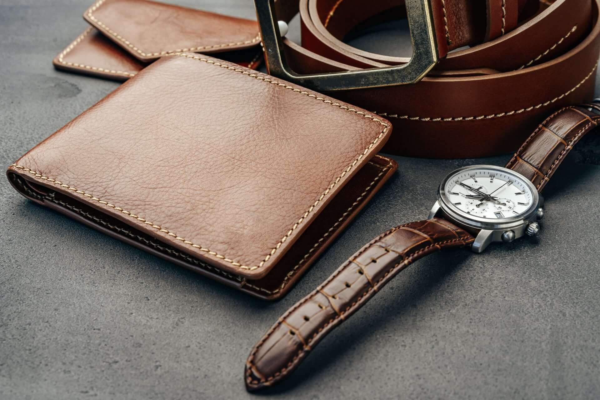 Male Watch And Leather Wallet On Dark Grey Surface Acggecu 2 - What To Consider When Buying Groomsmen Gifts Male Watch And Leather Wallet On Dark Grey Surface Acggecu 2 - What To Consider When Buying Groomsmen Gifts Gay Wedding Guide