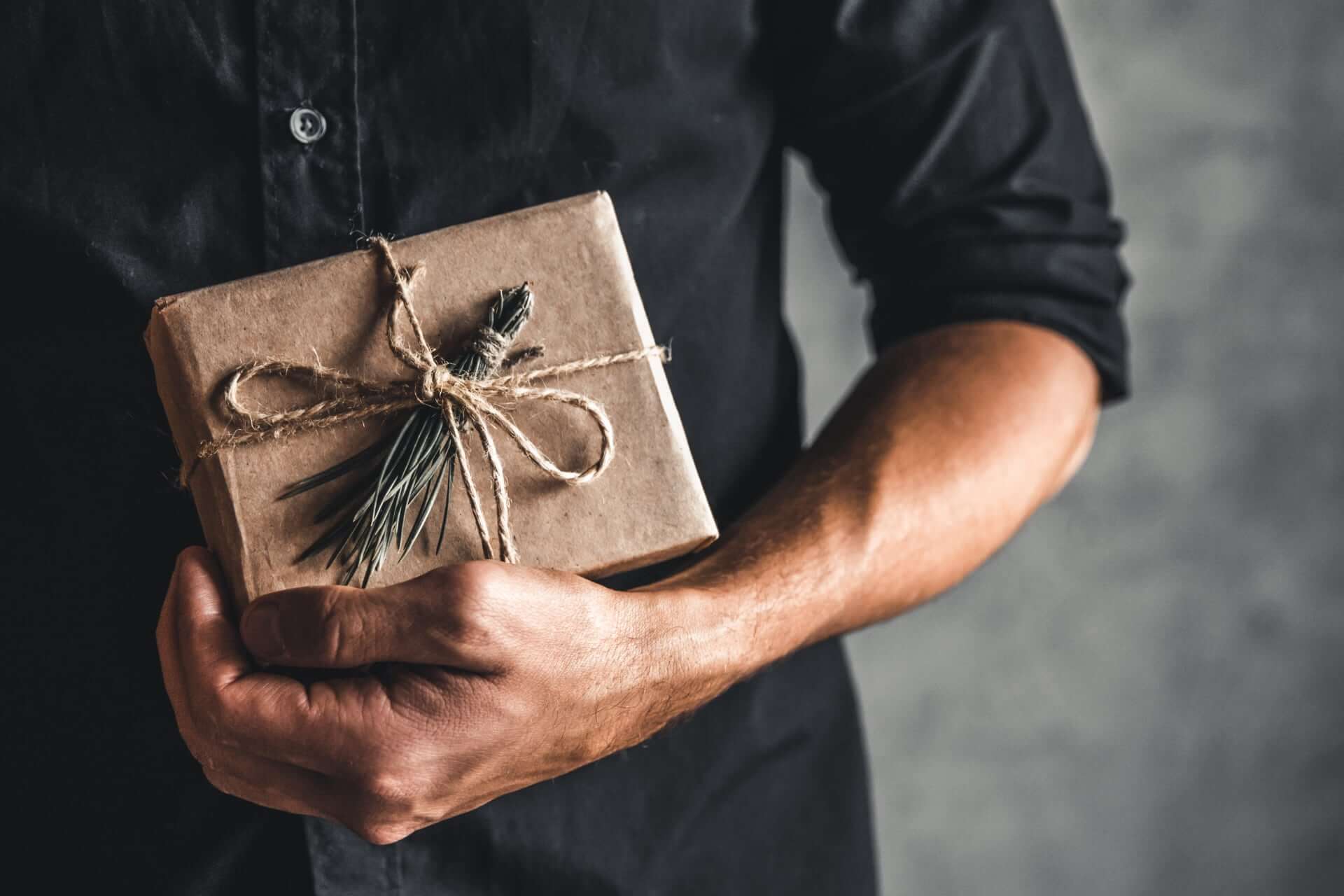 Man Holding A Gift Box Y557T8K 1 - What To Consider When Buying Groomsmen Gifts Gay Wedding Guide